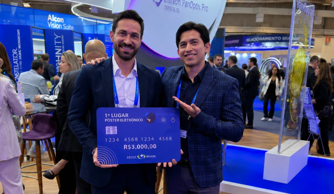 Two men in business attire pose at a conference, holding a large blue prize card that says '1° Lugar Poster Eletrônico' and 'R$3.000,00'.