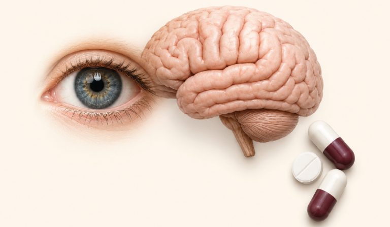 Close-up of a blue eye next to a brain model and three capsules on a pale background.
